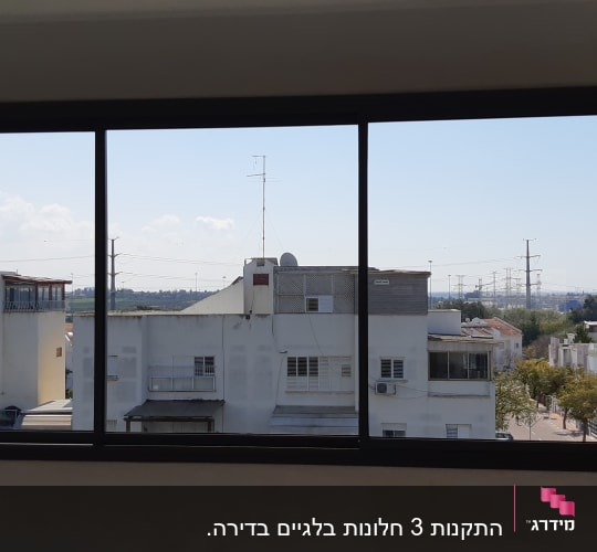 חלון אלומיניום עם נוף עירוני ברקע